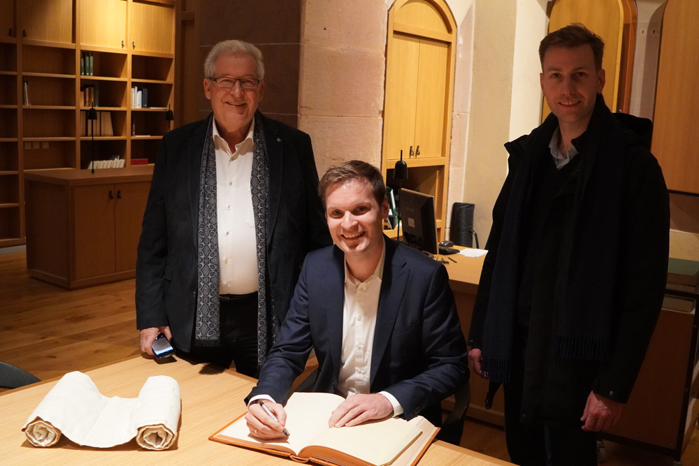 Yannick Bury durfte sich auf Einladung von Bürgermeister Marcel Bauer (links im Bild) im Beisein von Charles Sitzenstuhl (rechts im Bild) in das Goldene Buch der Stadt Sélestat eintragen.